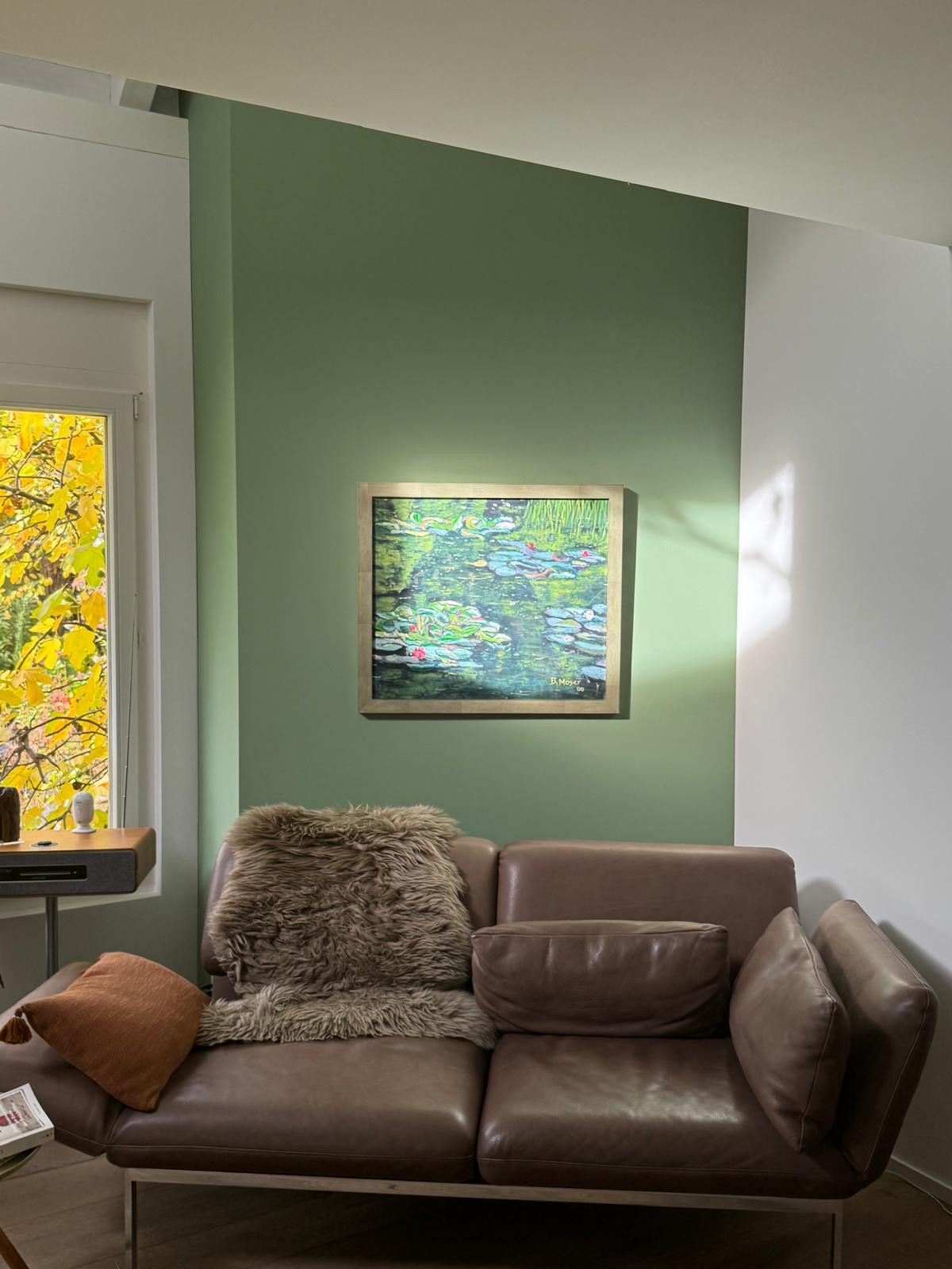 Salbeigrün gestrichene Wand mit Bild und Sofa