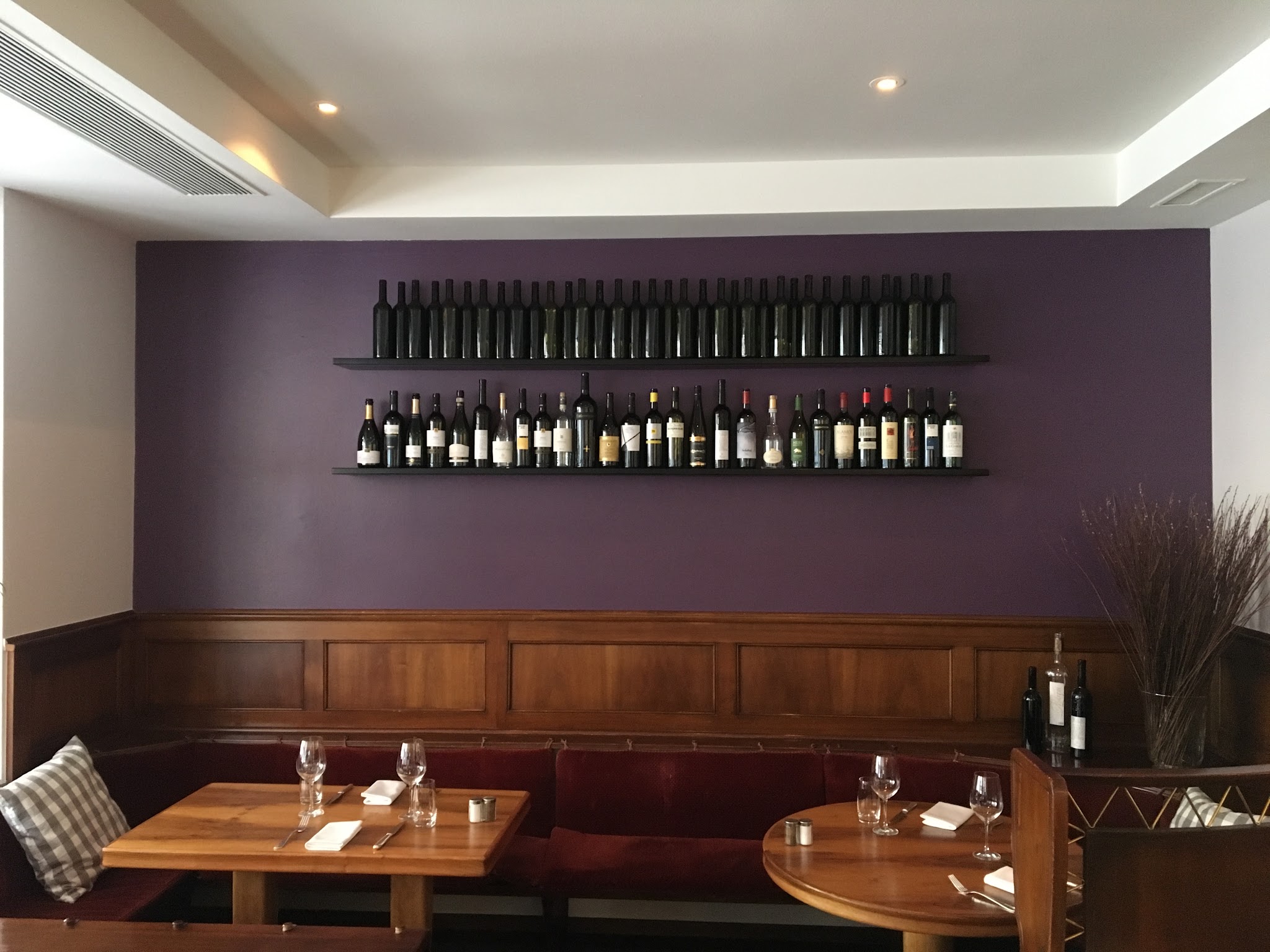 Lokal mit aubergine gestrichener Wand über dem Holztäfer