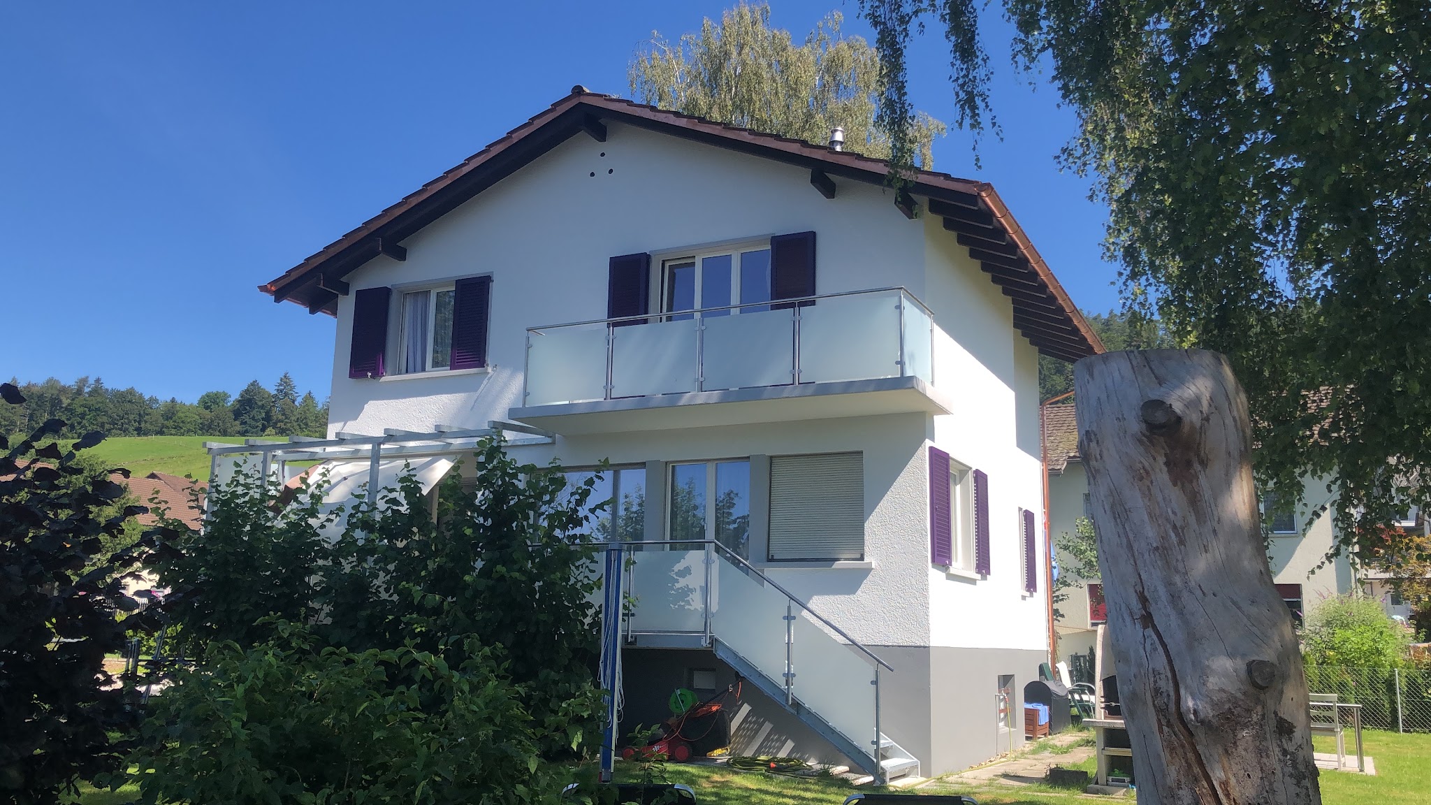 Wohnhaus mit Balkon und gestrichener Fassade unter blauem Himmel